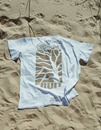 White Bearing Fruit t-shirt with graphic design on sand